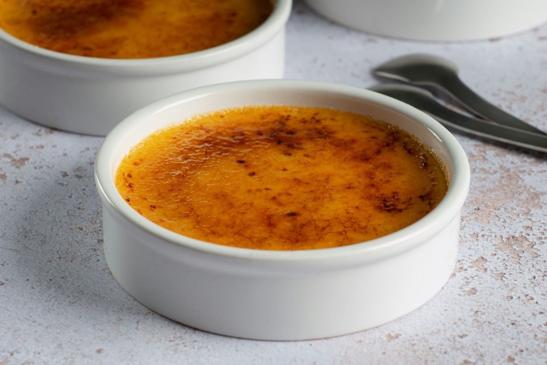 Masala Chai Crème brûlée with a caramelized crust in a white ramekin.