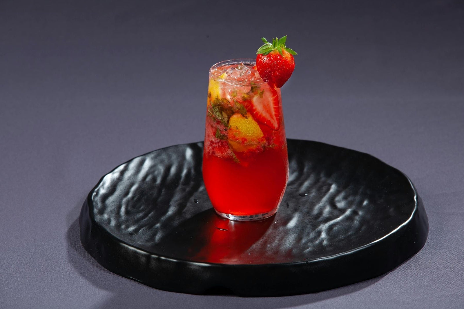 Winter Spiced Chai Sparkler mocktail served on a textured black plate.