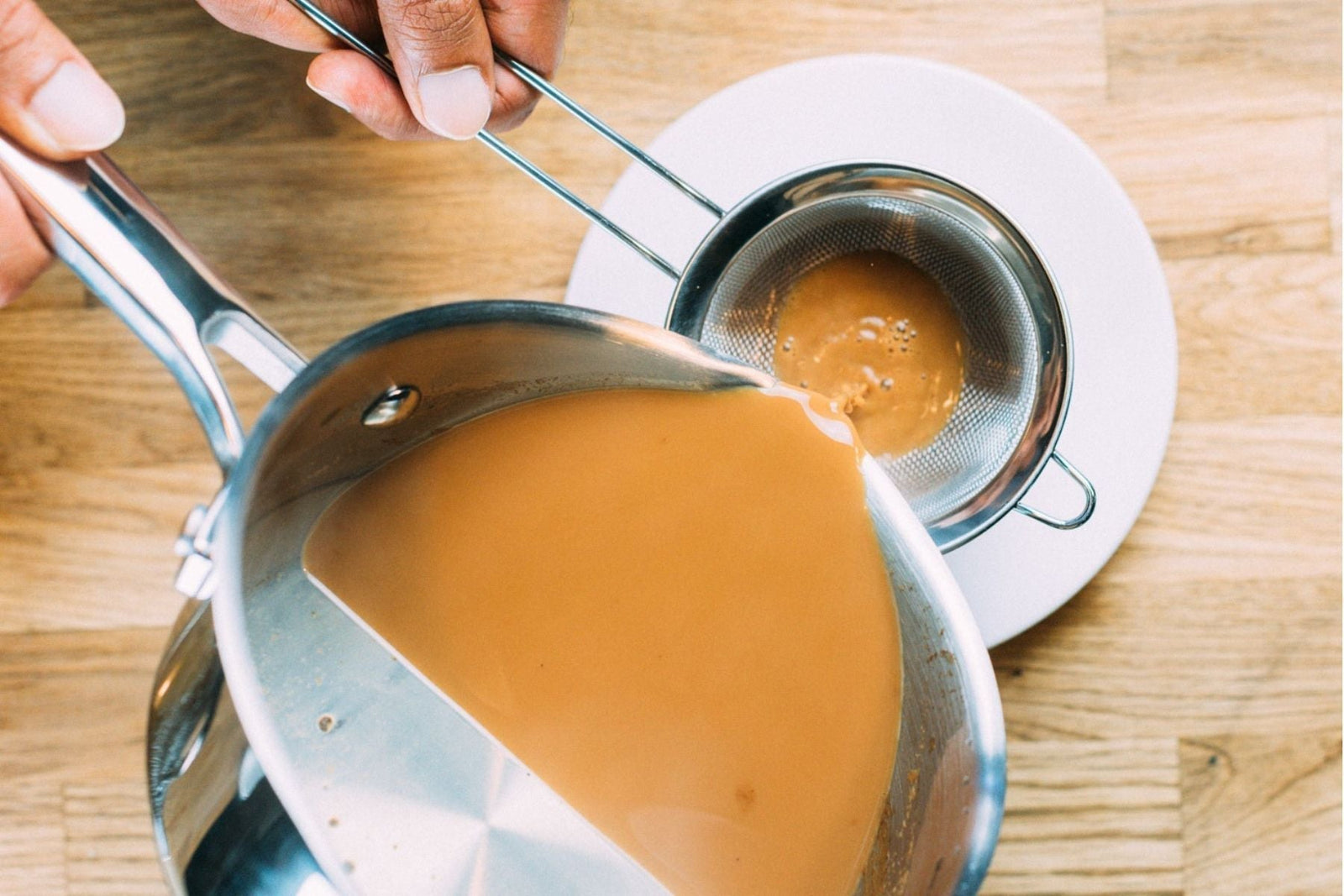 Tea being poured into a cup through a strainer