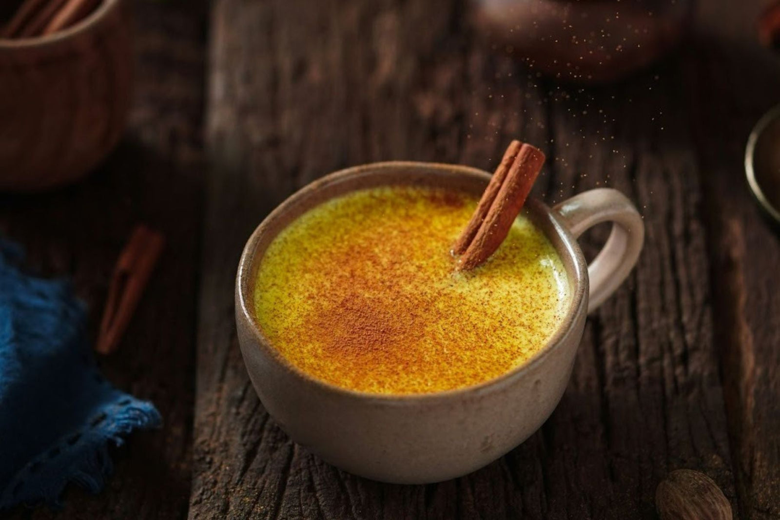 Turmeric Tea with a cinnamon stick dipped in it