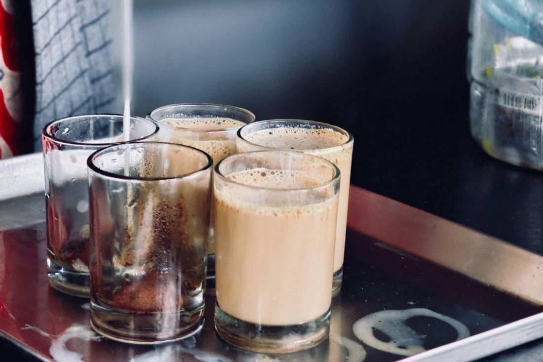Milk being poured into one glass amongst 5 glasses