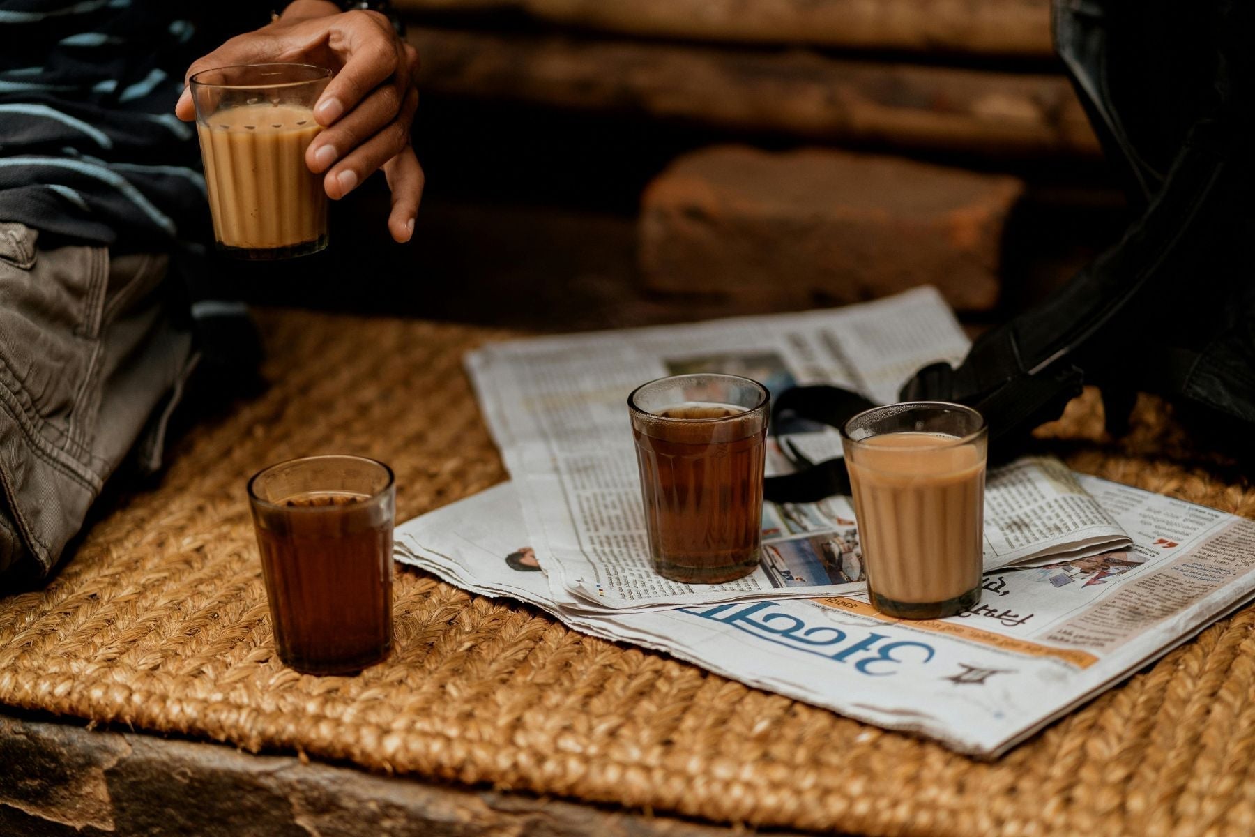 Glasses of chai served together on a newspaper during a casual tea break