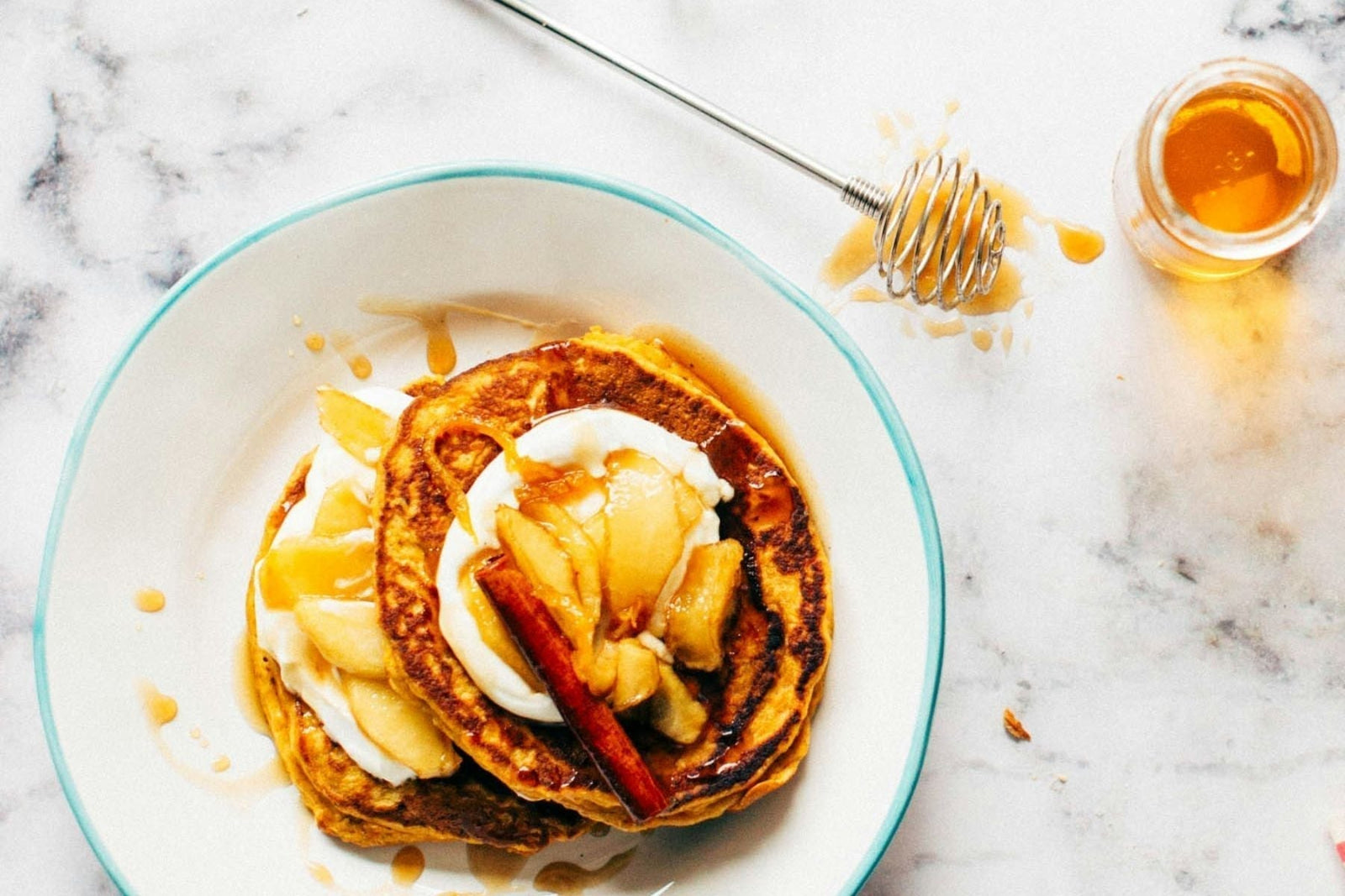 Pancakes topped with apples, cinnamon, yogurt and honey
