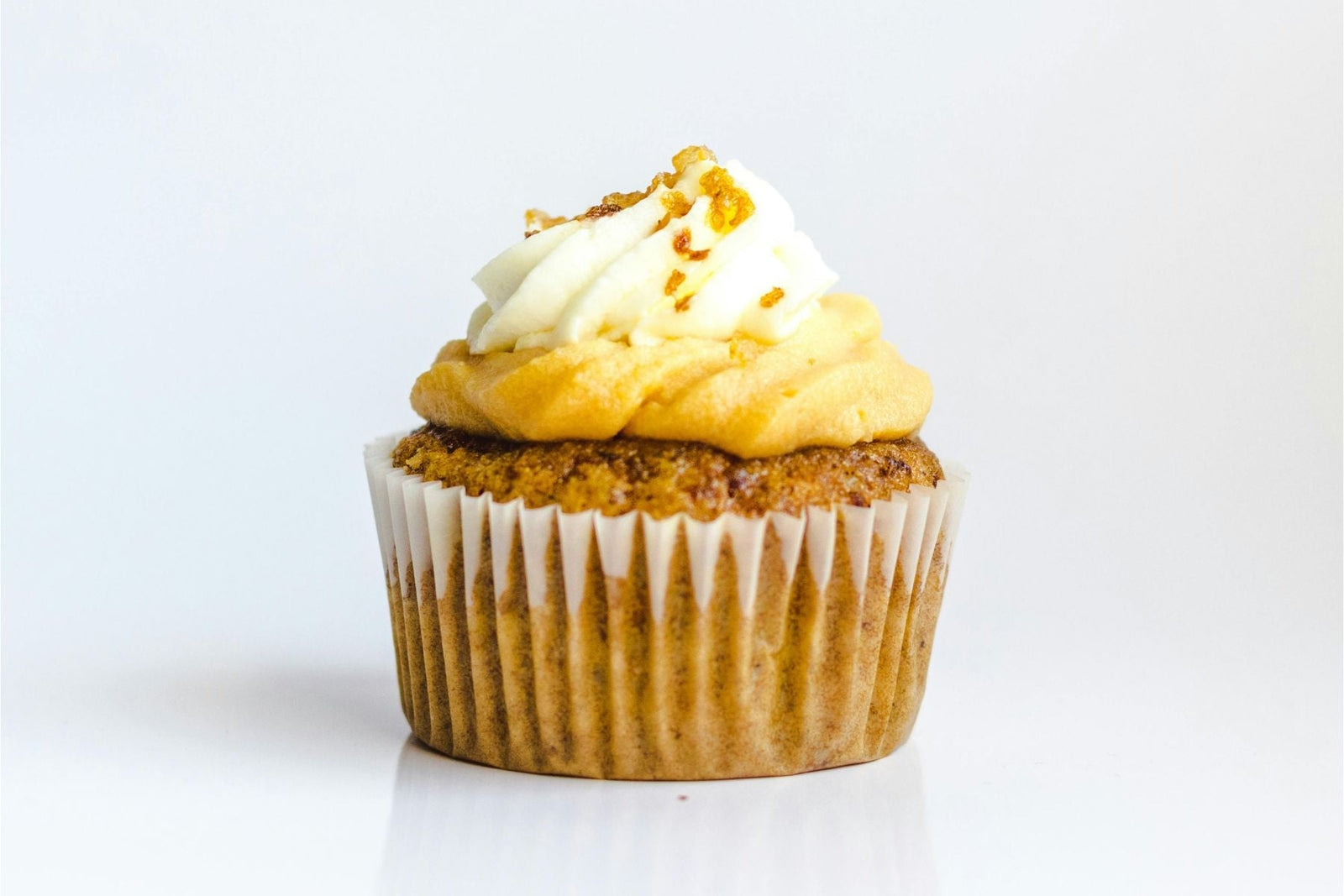 Vanilla cupcakes topped with white frosting and colorful sprinkles
