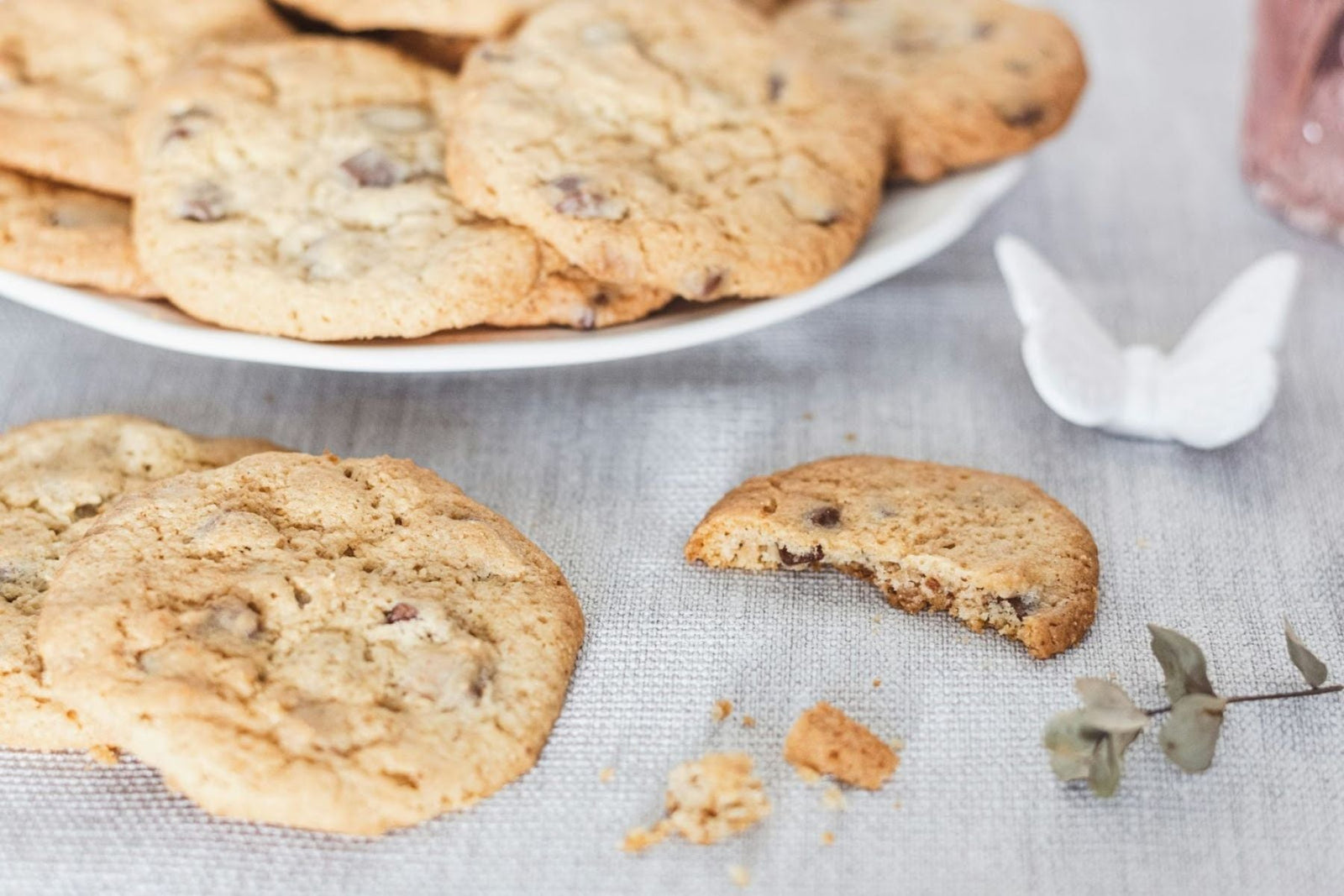 Plate of Chai spiced chip cookies with a bitten cookie nearby.