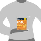 Tea package labeled 'Chai Moments' held by a person on a gray background