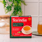 Box of Tea India Kashmiri Kahwa Green Tea on a kitchen counter with a candle and glass mug in the background.