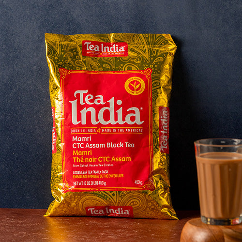 Tea India package with a glass of tea on a wooden surface against a dark background