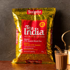Tea India package with a glass of tea on a wooden surface