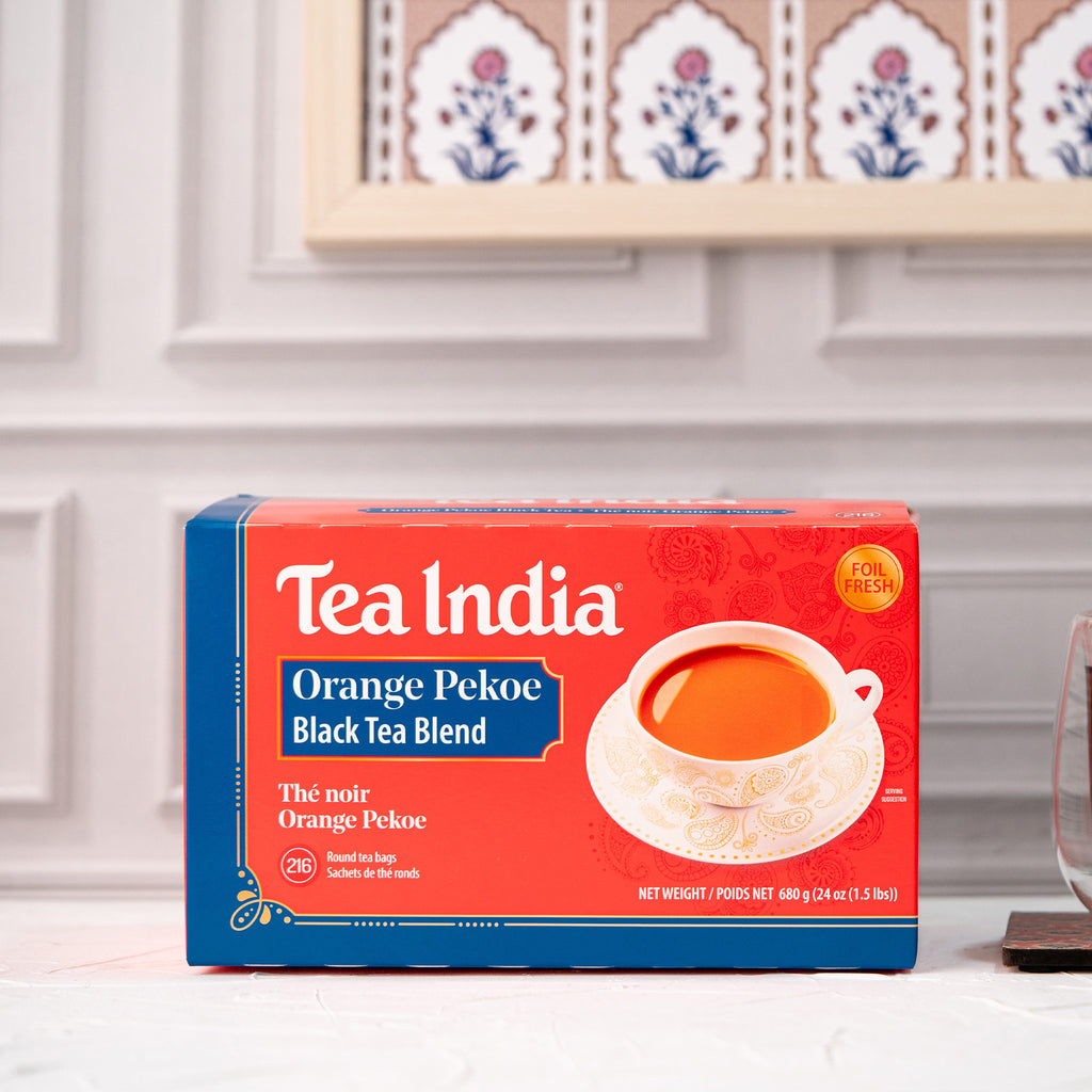 Box of Tea India Orange Pekoe Black Tea Blend on a kitchen counter with decorative plates in the background.