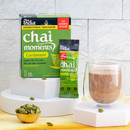 Tea India Chai Moments Cardamom No Sugar Added chai latte tea packaging with a cup of tea and cardamom pods on a white background