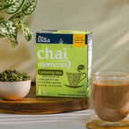 Chai Moments instant chai latte by Tea India in Lemongrass flavor, made with real milk and black tea, on a counter with a mug of chai and a bowl of fresh lemongrass