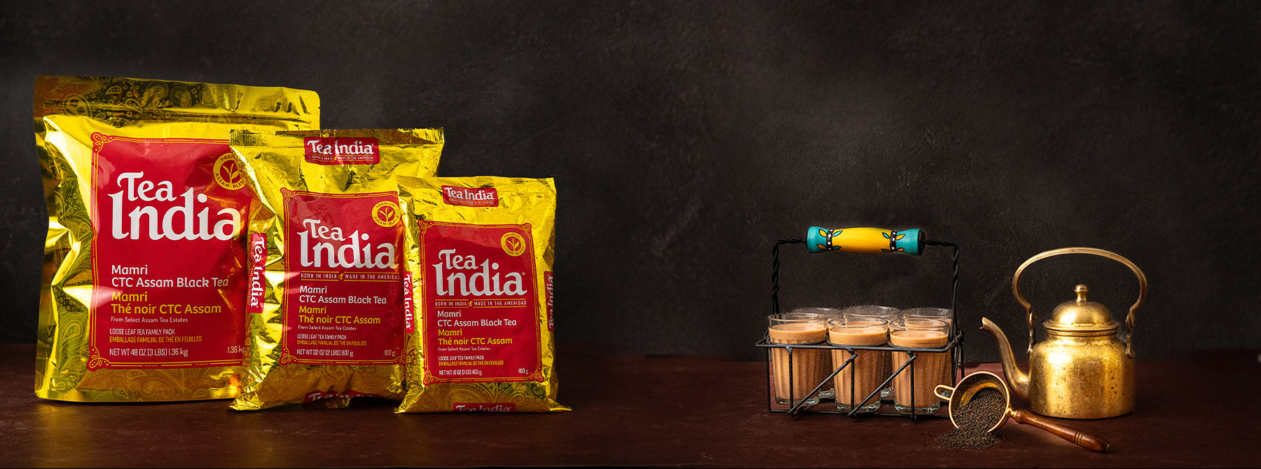 Tea India packages with a brass kettle on a dark background