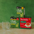 Three boxes of Tea India chai and black tea with a glass mug on a green background