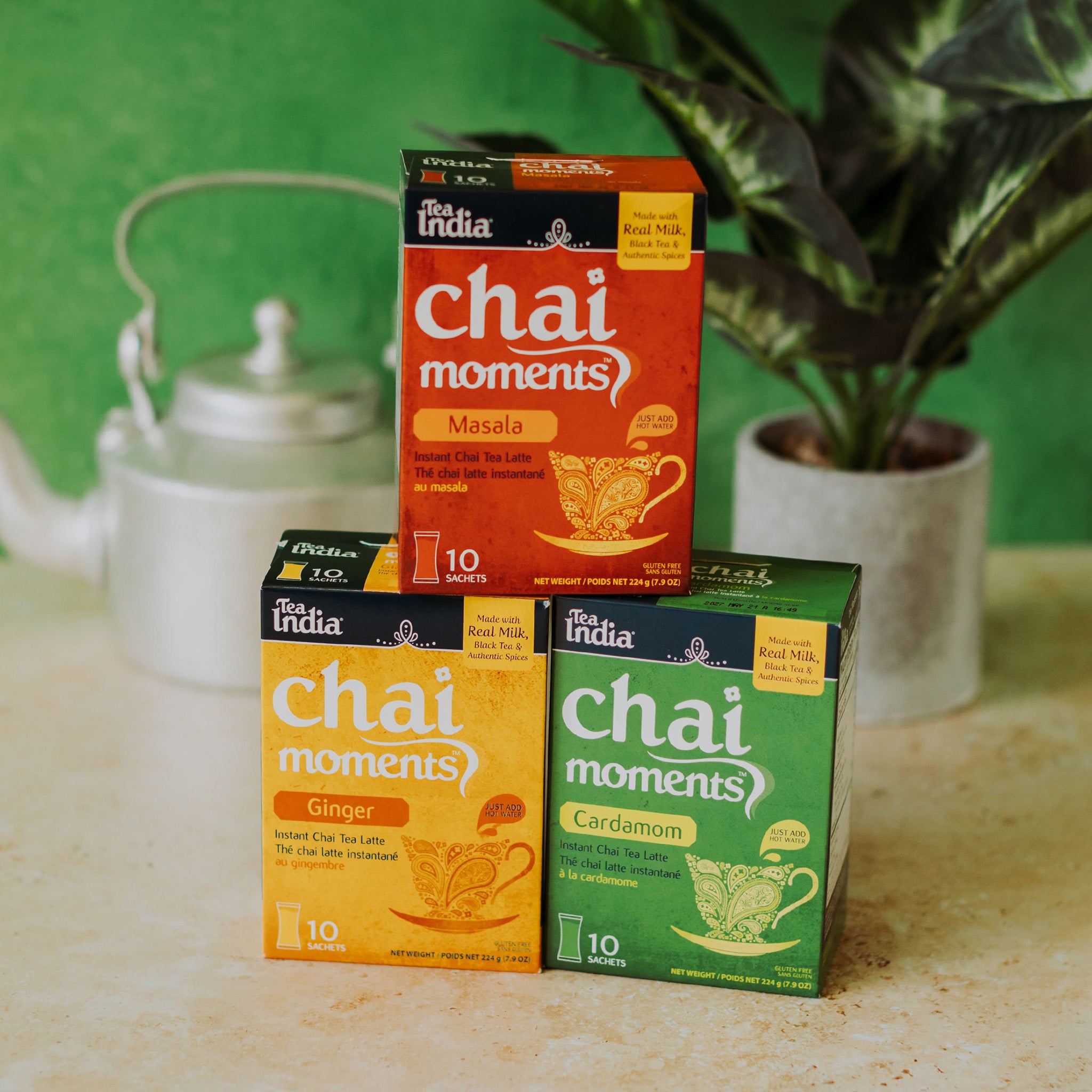 Masala, Ginger, and Cardamom chai moments instant latte flavors on a counter with a green background