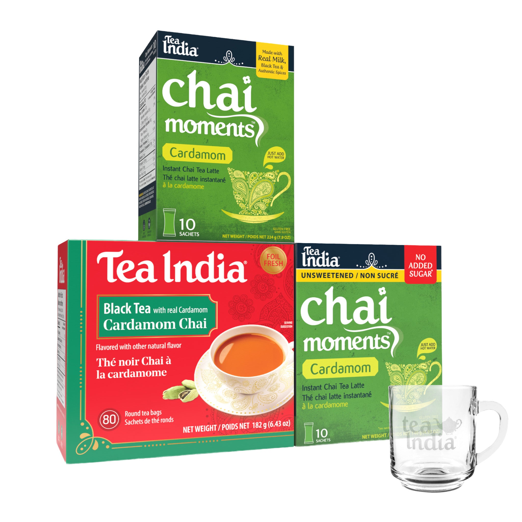 Tea India tea boxes with cardamom flavor 'chai moments' and 'Black Tea with Real Cardamom' on a white background and a clear glass mug