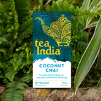 Tea India Coconut Chai tea bags box outdoors surrounded by green foliage