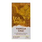 A box of Tea India Vanilla Chai tea bags, featuring a brown and gold ornate design on the top half and a white lower half with brown text, isolated on a white background.
