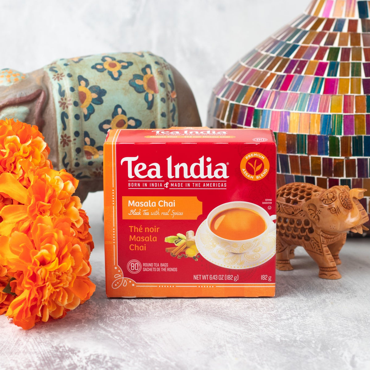 Tea India Masala Chai box placed with marigold flowers and traditional Indian decor elements